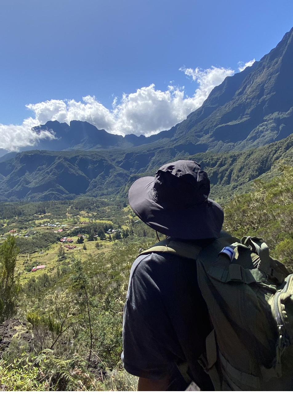 Hiker overlooking the Mafate cirque valley from the Col du Taïbit, near Cilaos, Reunion Island
