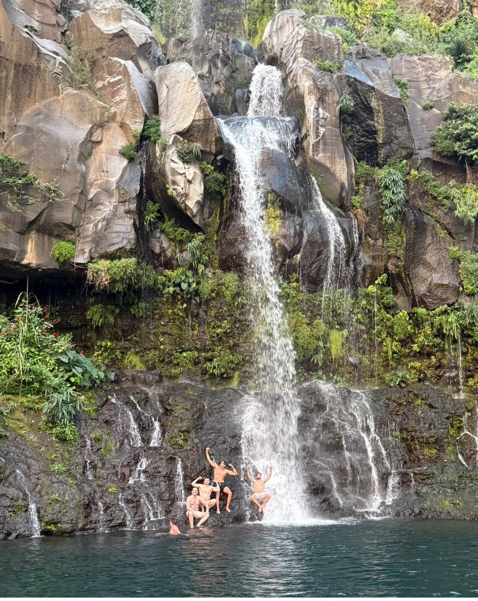 Carlos and friends jumping into a hidden waterfall in Reunion Island
