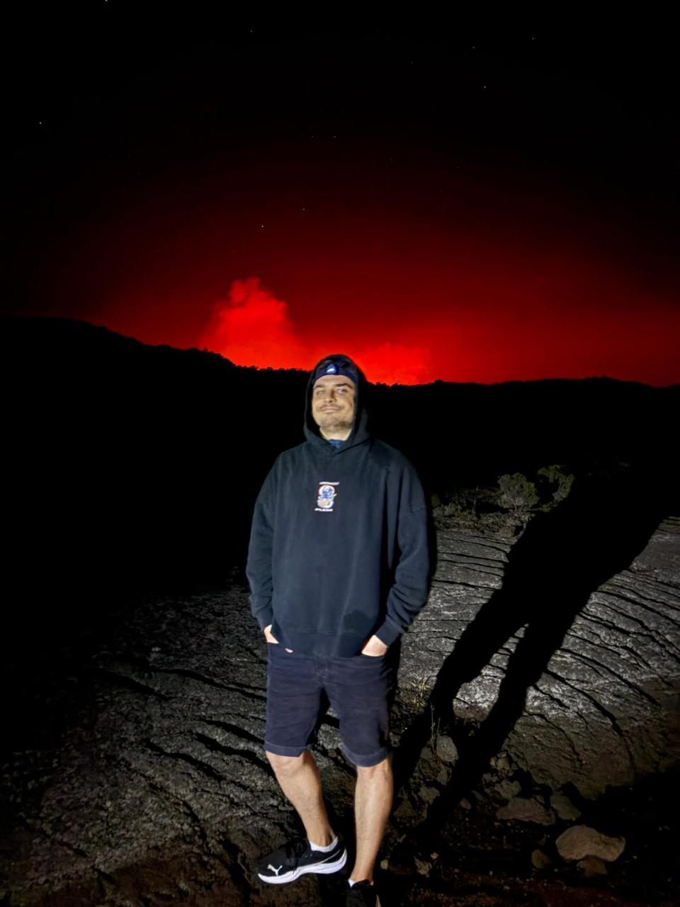 Maxim watching the glow of an erupting volcano at night, Reunion Island